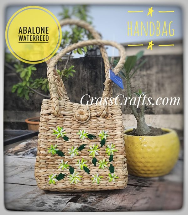 a handmade straw bag with flowers embroidered on it