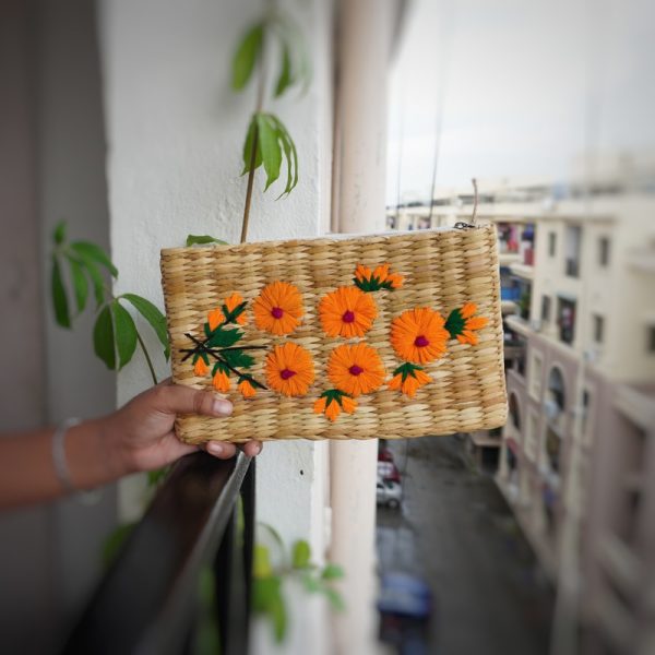 a handmade organic straw rectangular clutch with colorful flowers