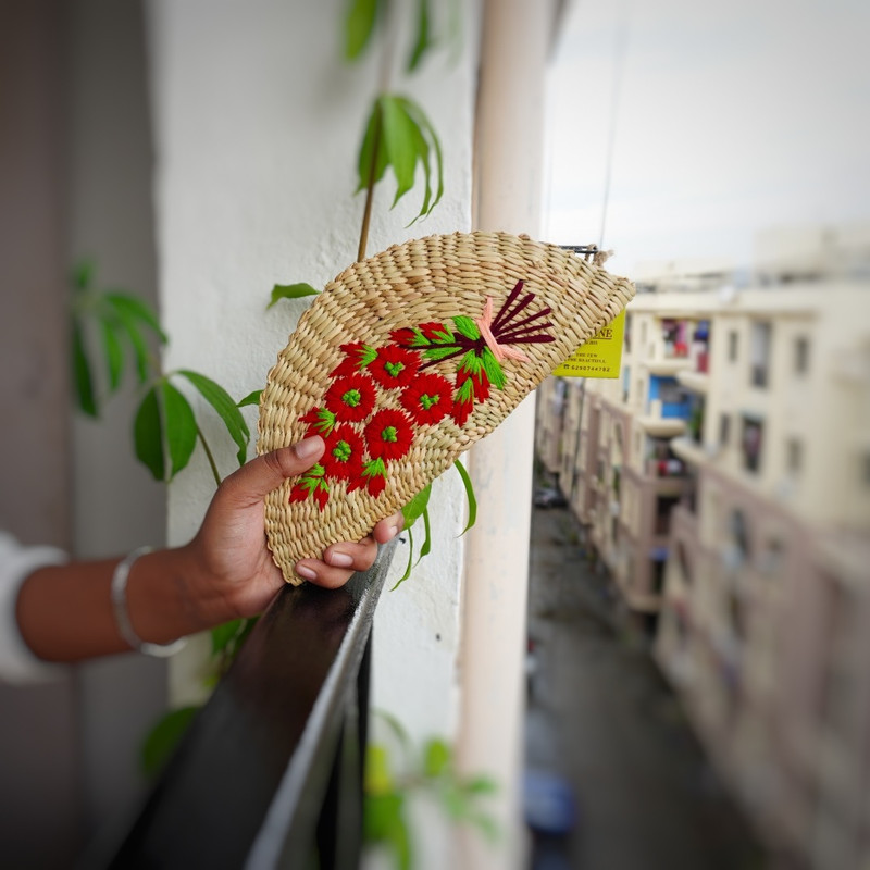a hand woven organic kauna clutch with colorful flowers