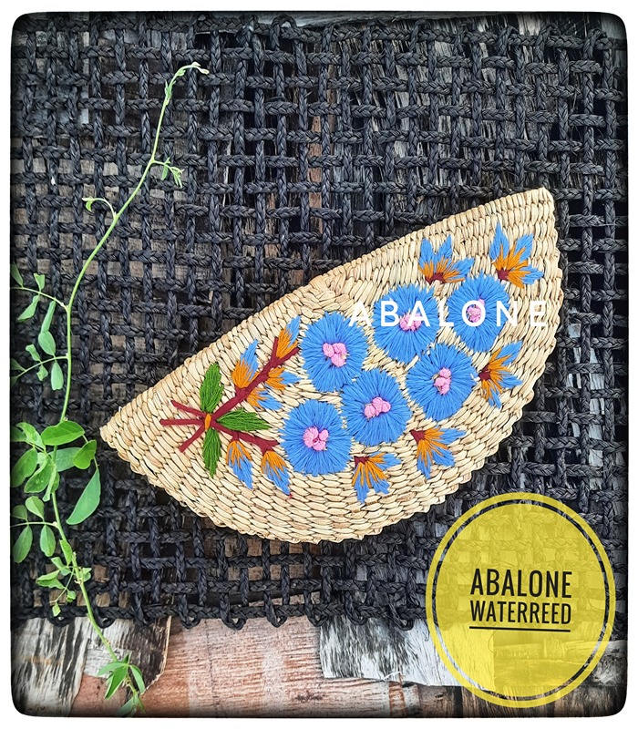 a hand embroidered organic kauna clutch with colorful flowers