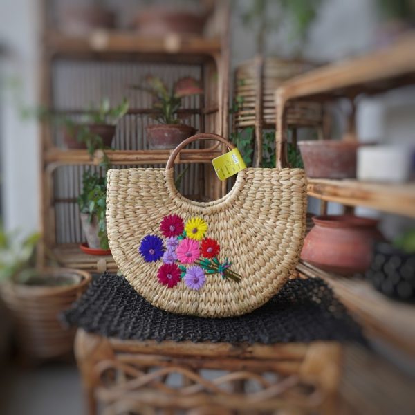 a hand woven kauna handbag or straw handbag with flowers embroidered on it